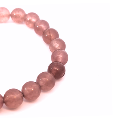 Detail van rozenkwarts edelsteen kralenarmband met glad gepolijste roze edelsteen kralen