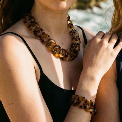 Model draagt een bruine transparante schakelketting met bijpassende armband van Casa Jadel
