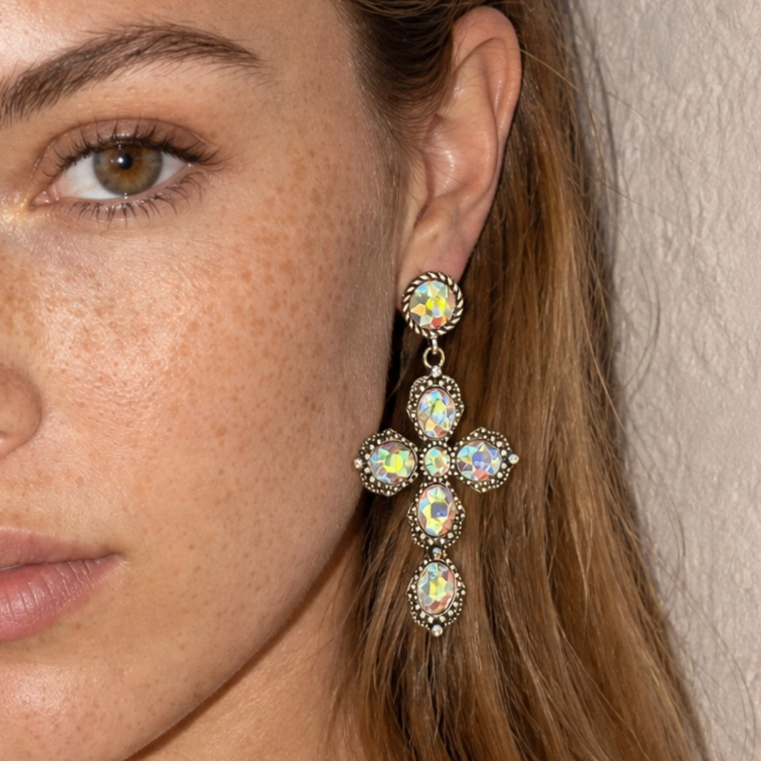 Close-up van model met grote statement kruis oorbel met glanzende strass stenen van Casa Jadel