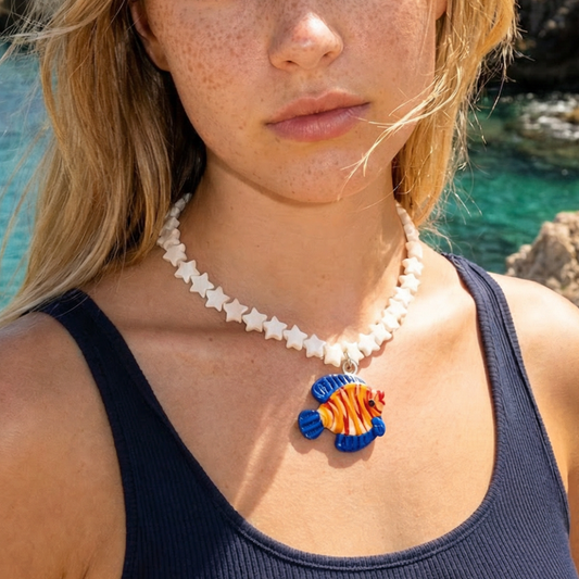 Model draagt sterren schelpenketting met oranje-blauw visbedel glas.
