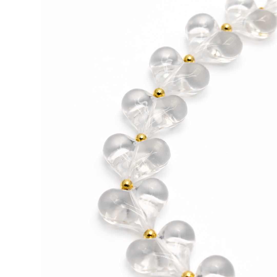 detail Transparante hartjes ketting met goudkleurige details en verlengketting.