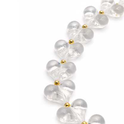 detail Transparante hartjes ketting met goudkleurige details en verlengketting.