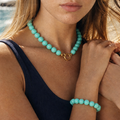 Modelt draagt grote kralenketting en kralenarmband in turquoise van Casa Jadel. Ibiza Style