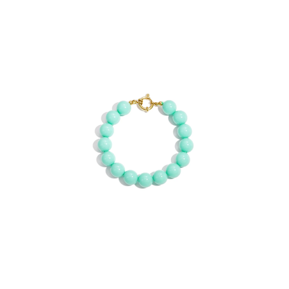 Turquoise kralenarmband met ronde kralen en goudkleurige sluiting op witte achtergrond
