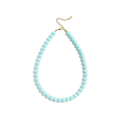 Turquoise kralenketting Olivia met ronde glaskralen en goudkleurige stainless steel sluiting van Casa Jadel op een witte achtergrond.