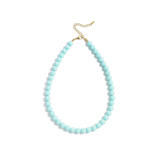 Turquoise kralenketting Olivia met ronde glaskralen en goudkleurige stainless steel sluiting van Casa Jadel op een witte achtergrond.