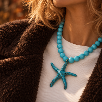 Model in de herfst met turquoise kralenketting Iris met 13,5 mm marble kralen en een oversized zeester bedel van 9 cm.