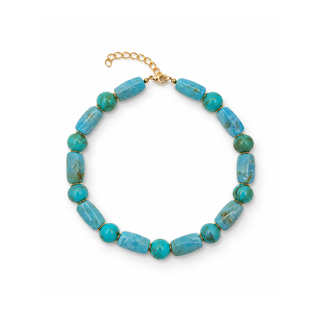 Turquoise kralenketting met langwerpige gemarmerde kralen, ronde groenturquoise kralen, goudkleurige tussenringetjes en een sluiting met verlengkettinkje.
