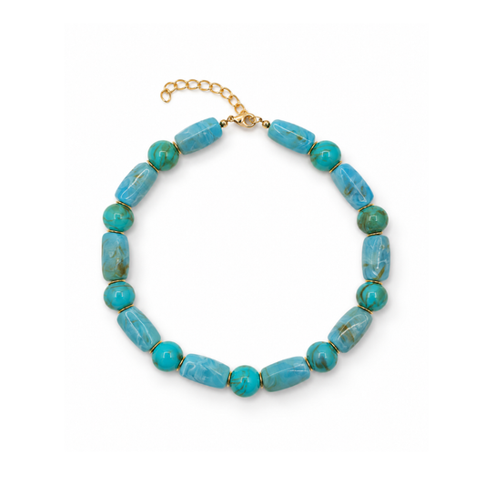 Turquoise kralenketting met langwerpige gemarmerde kralen, ronde groenturquoise kralen, goudkleurige tussenringetjes en een sluiting met verlengkettinkje.