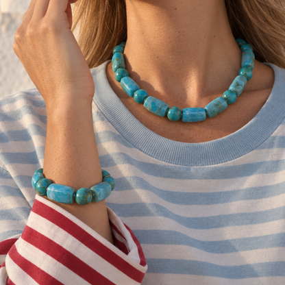 Model in gestreepte trui draagt de turquoise long & round marble kralenketting en bijpassende kralenarmband.