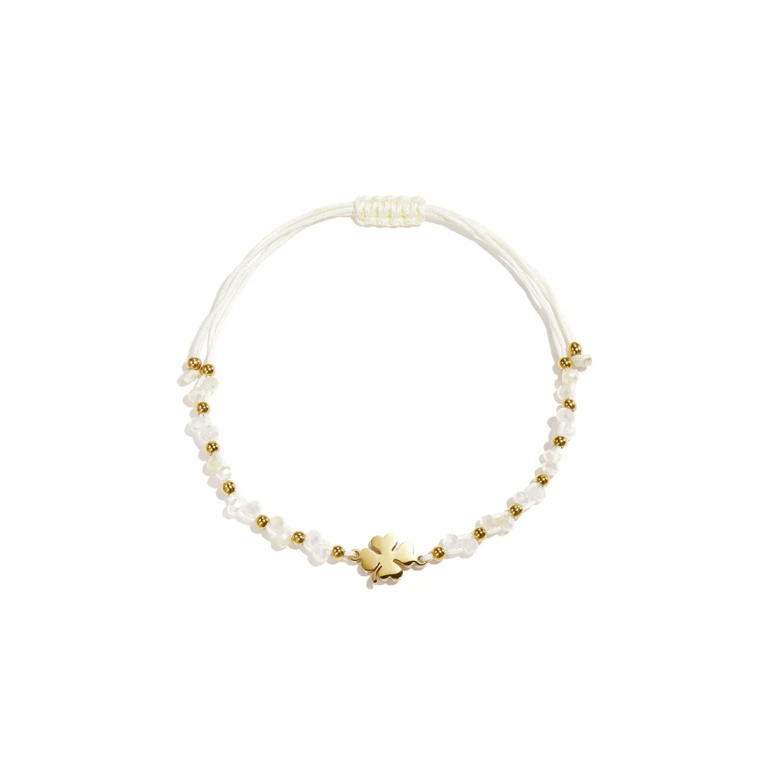 Wit touw armbandje met gouden klavertje, witte kraaltjes en gouden details van Casa Jadel.