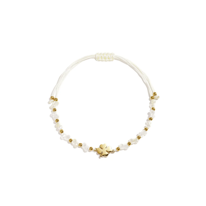 Wit touw armbandje met gouden klavertje, witte kraaltjes en gouden details van Casa Jadel.