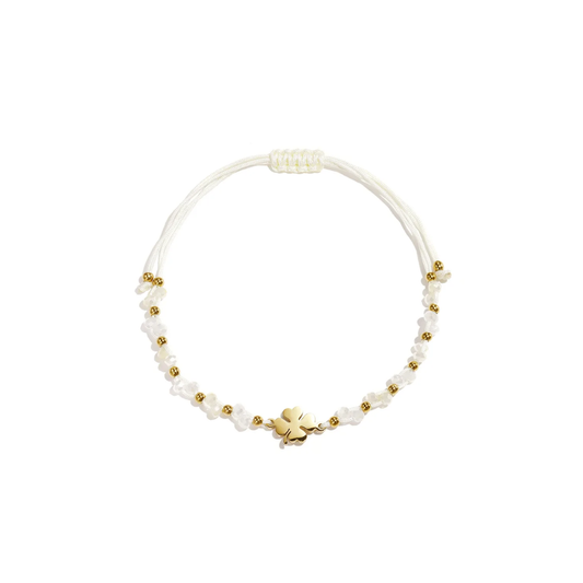 Wit touw armbandje met gouden klavertje, witte kraaltjes en gouden details van Casa Jadel.