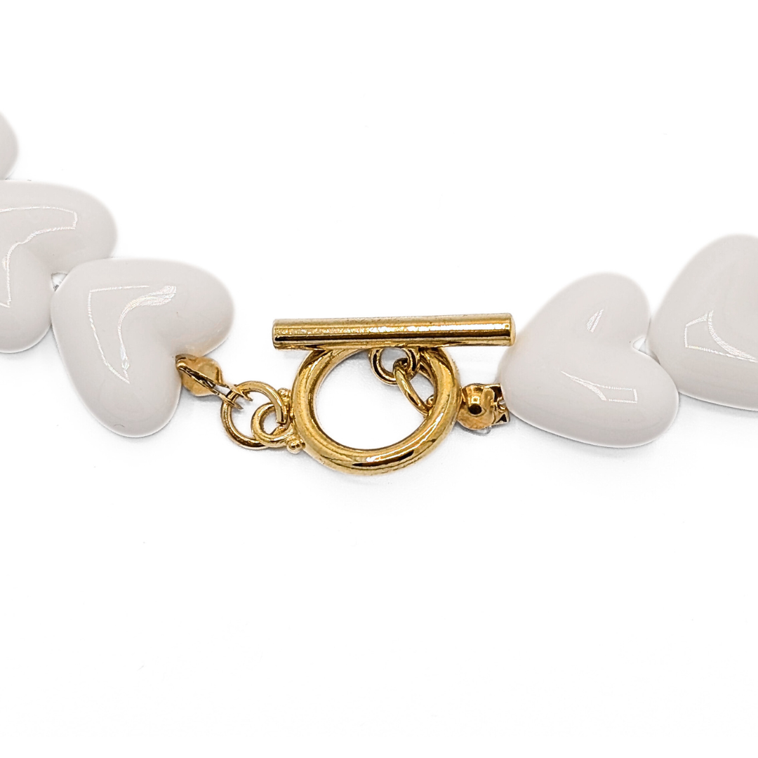 Detail van witte hartjes kralenketting met gouden toggle frontsluiting Ibiza style sieraden Casa Jadel