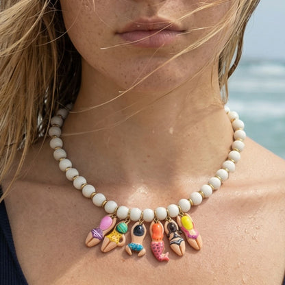 Witte kralenketting met kleurrijke bikini en zeemeermin bedels gedragen op het strand – zomerse Ibiza style ketting voor dames van Casa Jadel.
