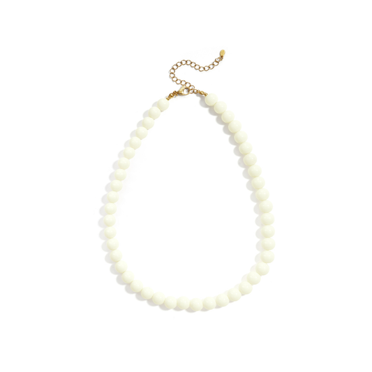 Witte kralenketting met ronde glanzende kralen en goudkleurige sluiting op witte achtergrond