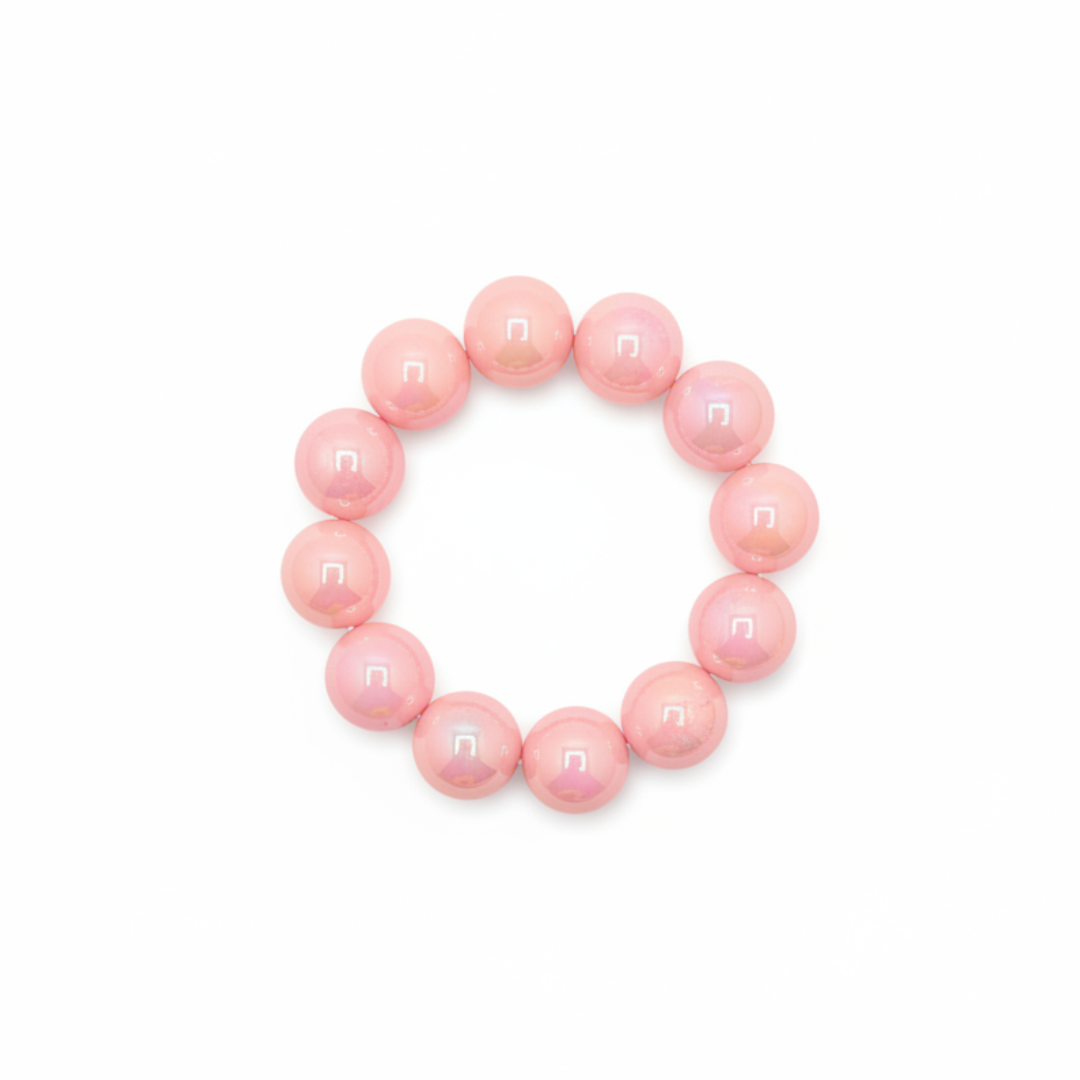 Zachtroze chunky kralenarmband met grote glanzende kralen op lichte achtergrond schuin.