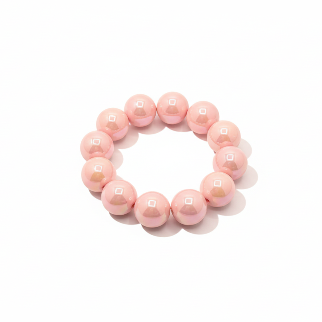 Zachtroze chunky kralenarmband met grote glanzende kralen op lichte achtergrond.