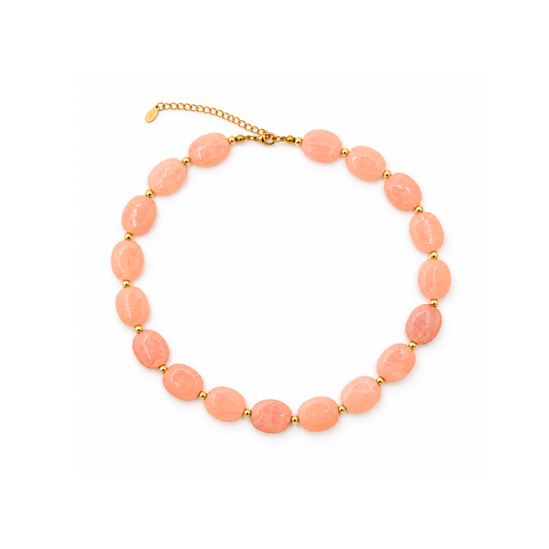 Zalmroze marble ovale kralenketting Gigi met platte, licht doorschijnende kralen, witte marmertekening en kleine goudkleurige kraaltjes.