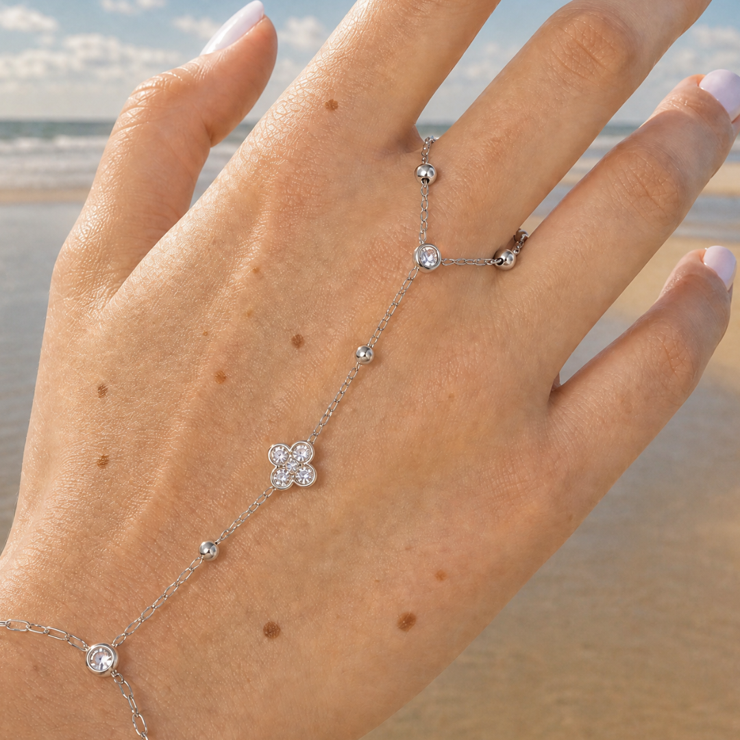 Zilveren hand chain met armband ring en diamant lover gedragen door model.