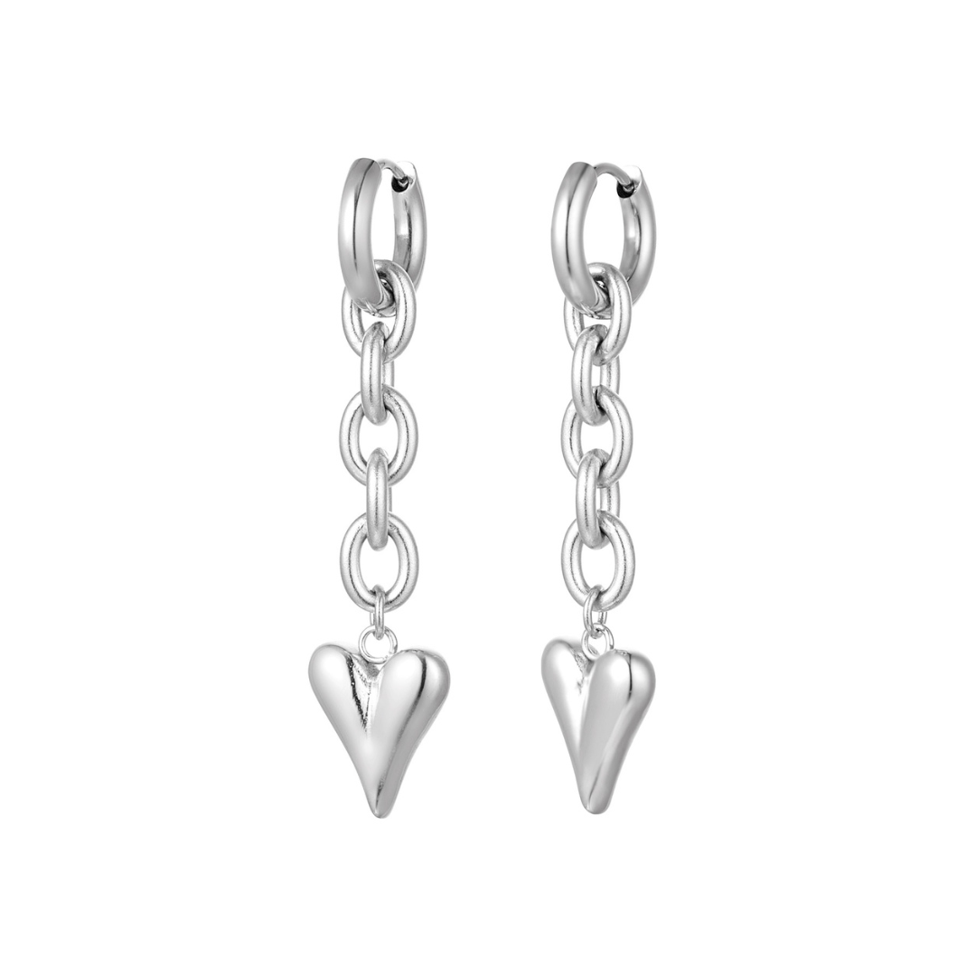 Zilveren oorring met schakelketting en hangend hartje detail op witte achtergrond.