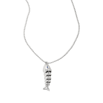 Zilveren ketting met gedetailleerde vis bedel aan fijne bolletjesketting op lichte achtergrond.