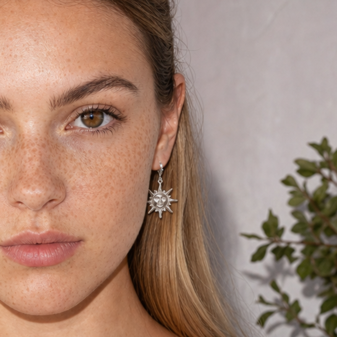 Model draagt zilveren oorbel met zon bedel van Casa Jadel