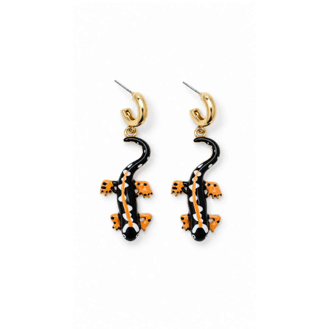 Zwart-gele salamander oorbellen met zwart lijf, witte stippen en oranjegele pootjes aan een chunky goudkleurig oorringetje op een witte achtergrond.
