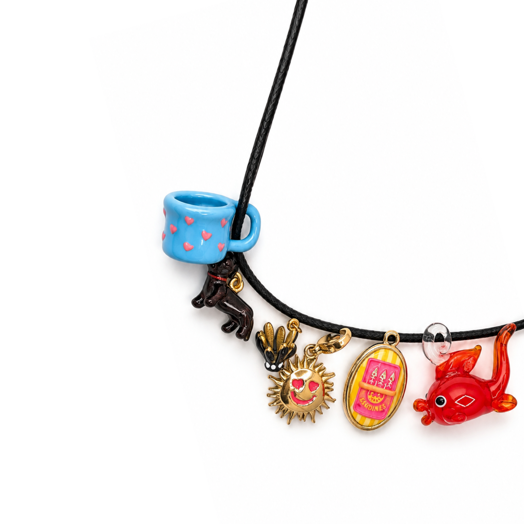 Zwarte basic koordketting met verschillende kleurrijke bedels, zoals een blauw kopje, een zonnetje en een rood glazen visje.