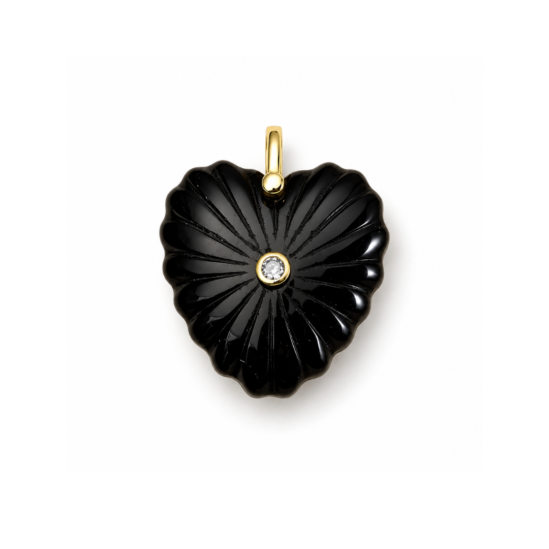Zwarte obsidiaan hartbedel met uitgesneden reliëf, helder middensteentje en goudkleurig ophangoog, 32 × 30 mm.