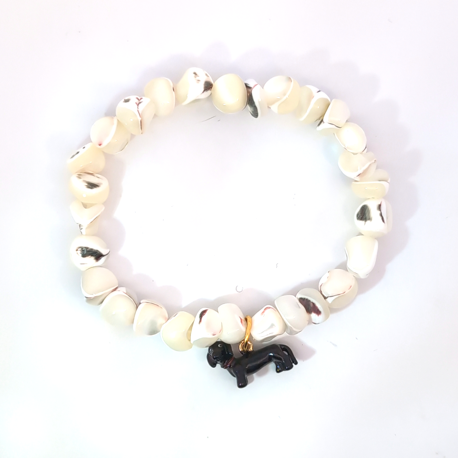 Zwarte teckel hond bedel gedragen aan kralenarmband van natuurstenen, Jadel sieradenstijl